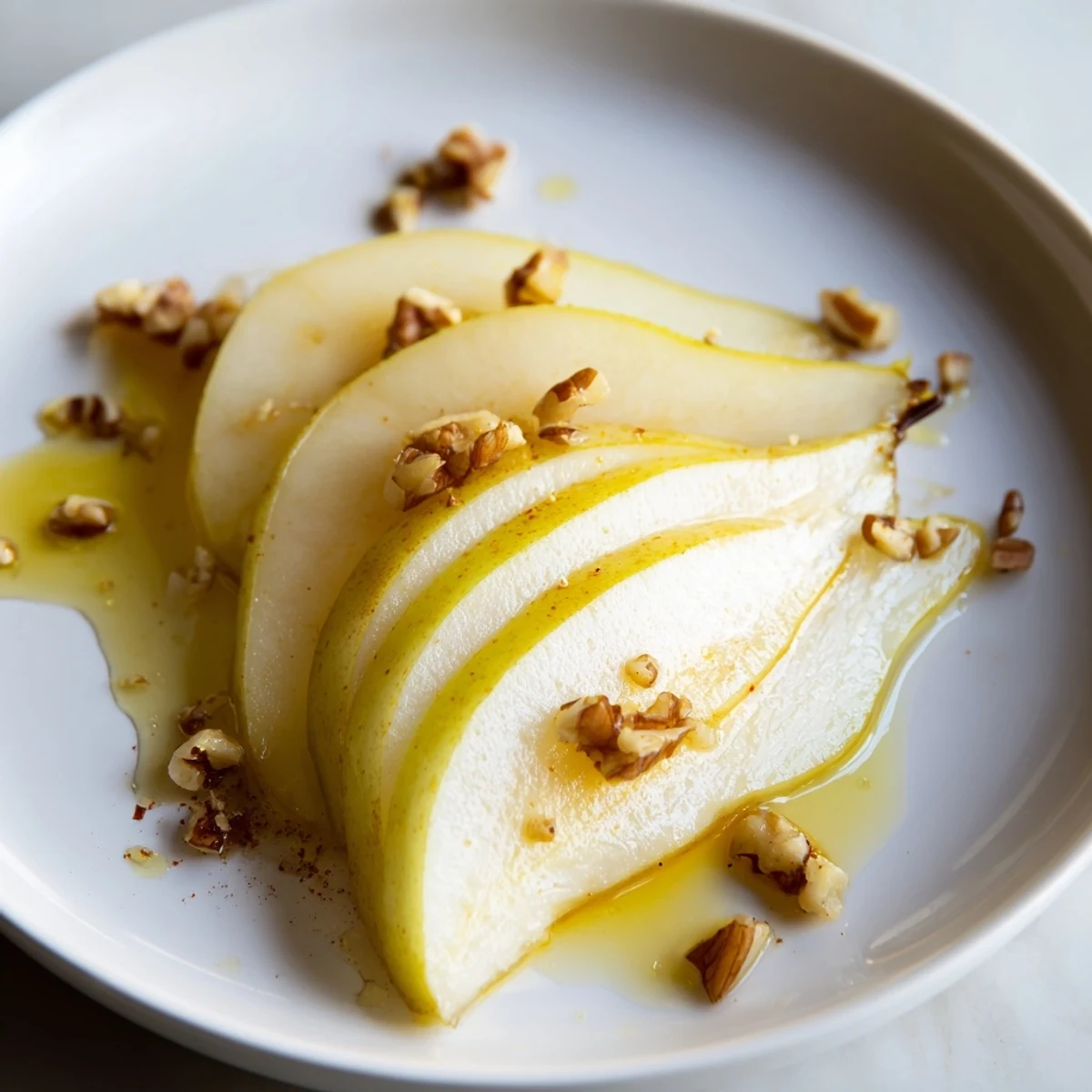 Fresh pear slices with golden honey drizzle, a simple and delightful dessert.