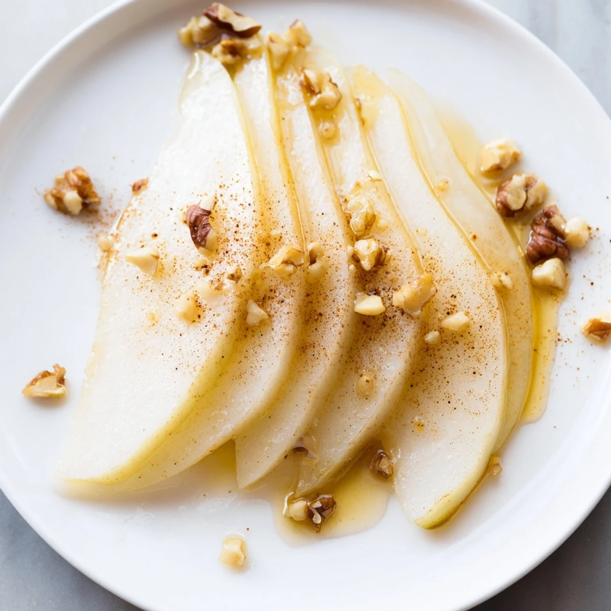 Vibrant, sweet pear slices arranged on a plate, topped with glistening honey drizzle.