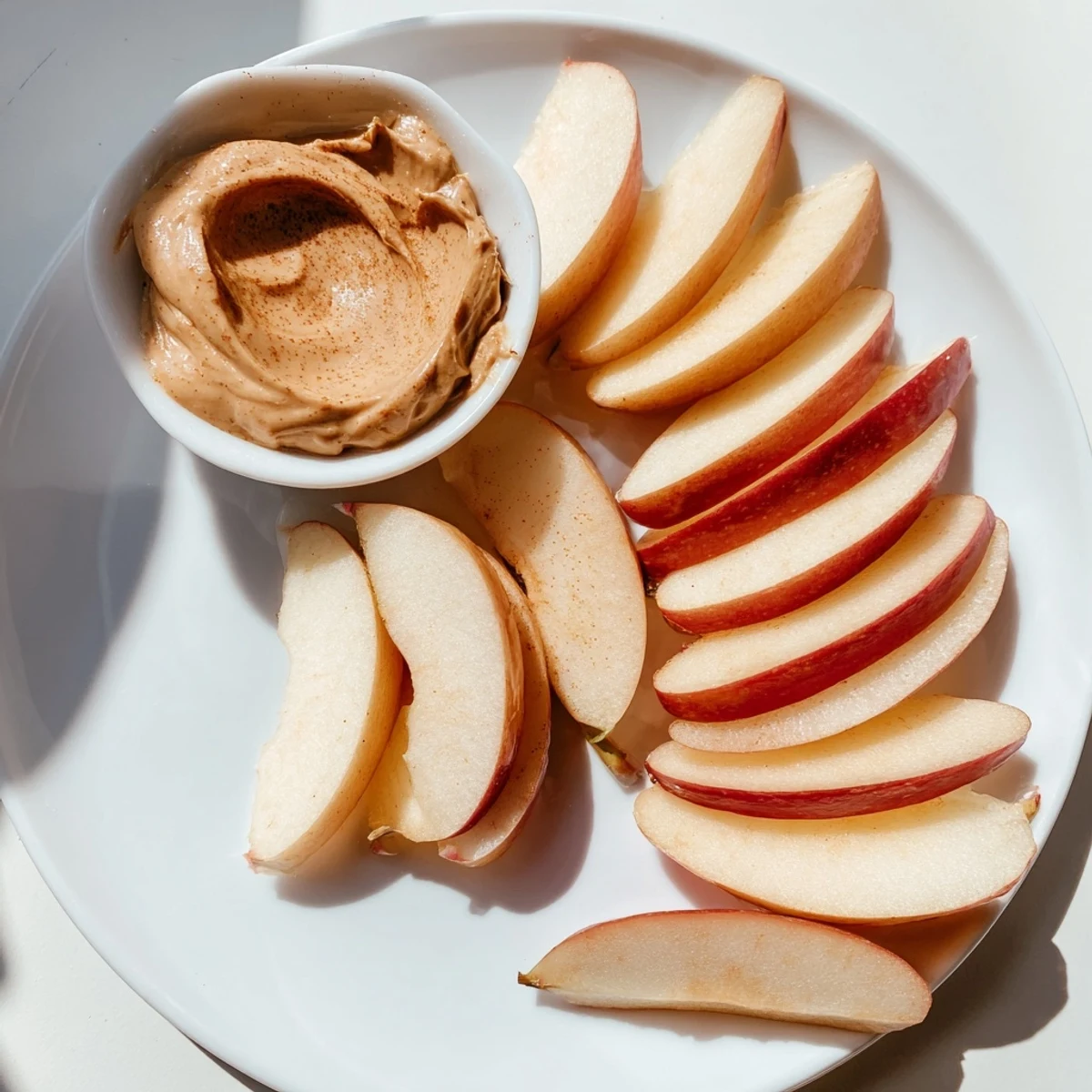 Fresh apple slices showcasing a creamy peanut butter dip, a quick, easy snack.
