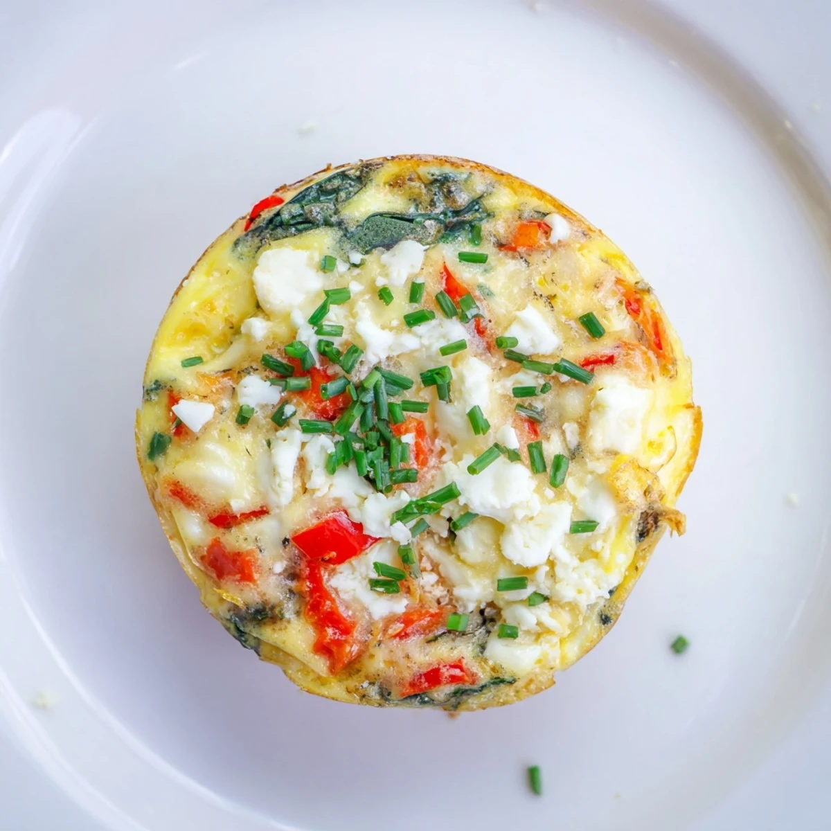 Golden, bubbly Mini Crustless Quiches filled with spinach, ready to serve with a side salad.