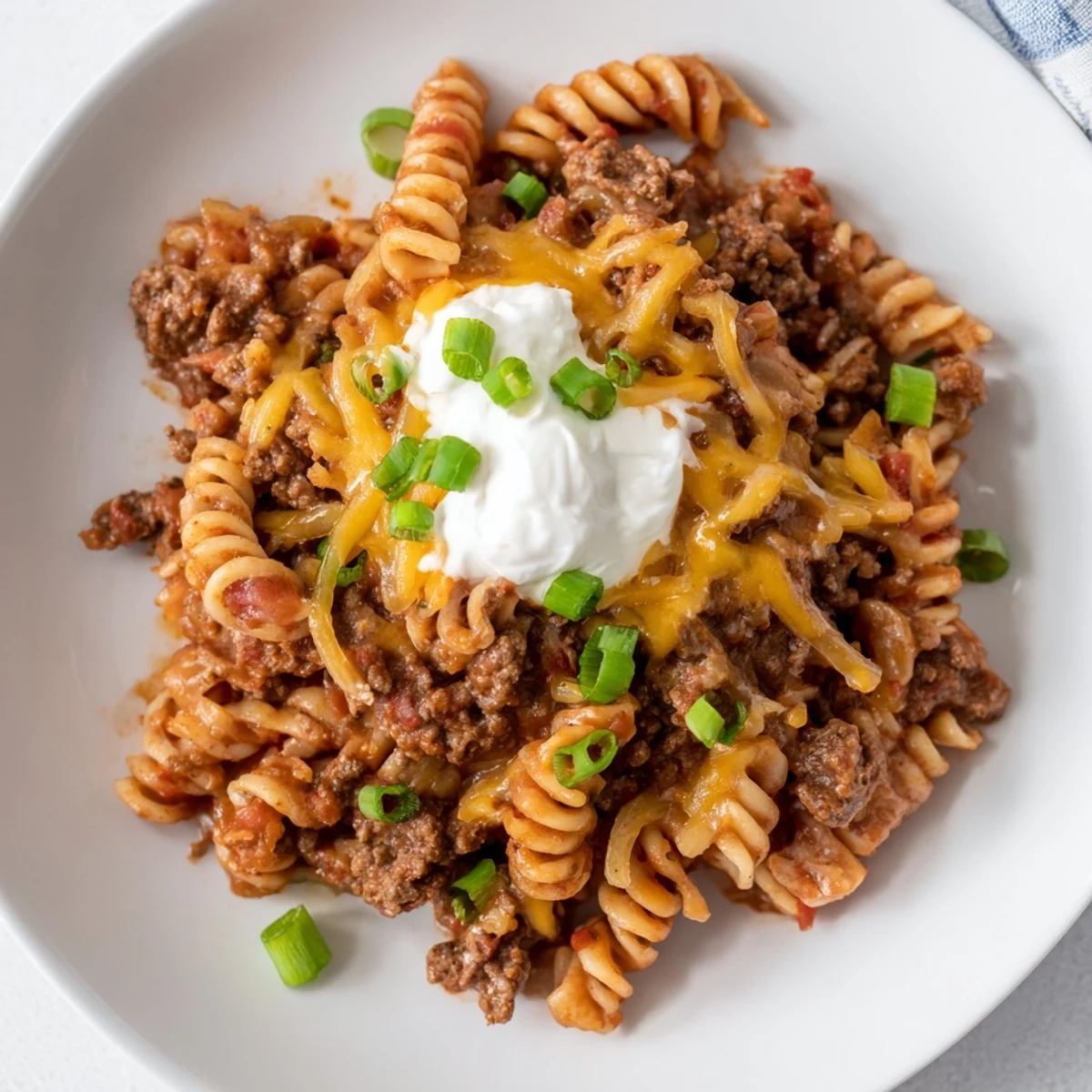 Enjoy a family-friendly view of bubbling one-pot taco pasta, a hearty meal with pasta and spices.