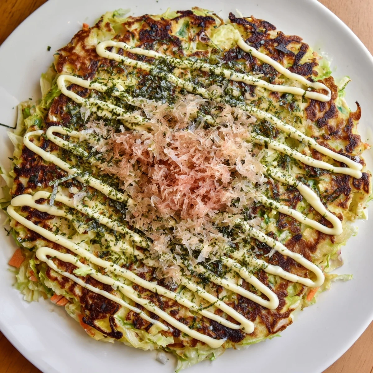 Steaming Japanese okonomiyaki pancakes, savory and loaded with cabbage, drizzled with flavorful okonomiyaki sauce.