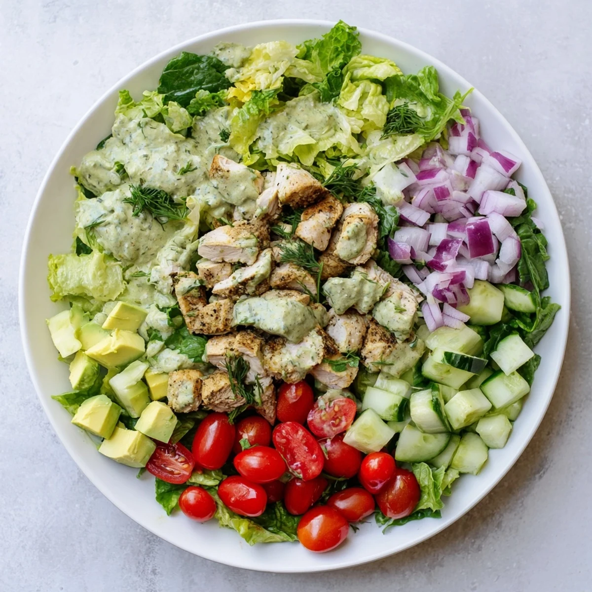 Grilled chicken chunks tossed in creamy avocado ranch dressing over fresh greens, tomatoes, and cucumbers for this refreshing Avocado Ranch Chicken Salad.  
