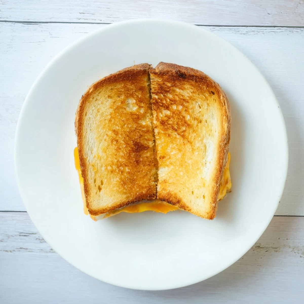 A perfectly golden, crispy Three-Cheese Grilled Cheese sandwich, oozing with melted mozzarella, cheddar, and provolone on sourdough.  