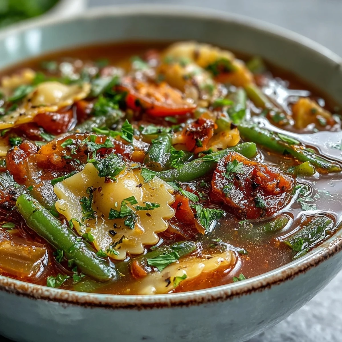 Freshly prepared Minestrone Soup in a rustic bowl, served with crusty bread on the side for dipping.