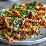 Golden Crispy Chicken Wonton Tacos topped with vibrant green cilantro, red cabbage, and lime wedges on a rustic platter.