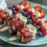 Festive Fourth of July red white blue fruit skewers with strawberries, bananas, and blueberries for patriotic celebrations.