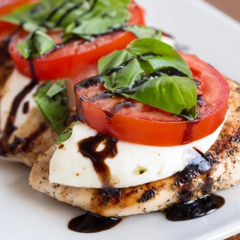 Golden-brown Caprese Chicken Skillet with melted mozzarella, juicy tomatoes, and fresh basil leaves.  