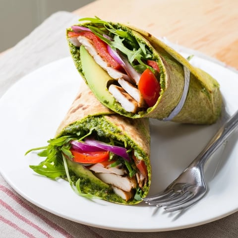 A vibrant Chimichurri Chicken Salad Wrap with fresh greens and avocado slices, resting on a wooden cutting board.