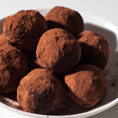 A close-up of perfect dark chocolate truffles, a creamy and satisfying indulgence.