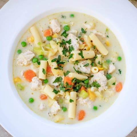 Cozying up with Chicken Pot Pie Pasta Soup, steaming and ready to enjoy with parsley.
