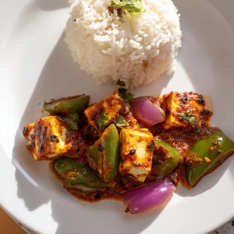 Fragrant Paneer Tikka Masala, with colorful bell peppers, cooked in a rich, spiced tomato sauce.