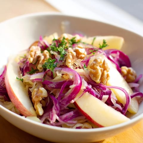 Hearty German-inspired Warm Apple and Sauerkraut Skillet Salad served warm, garnished with fresh parsley and optional walnuts.  