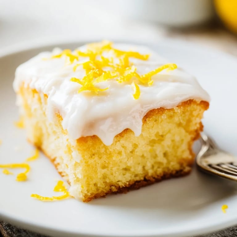 Slice of freshly baked Lemon Loaf Cake featuring a vibrant citrus flavor and sweet icing.
