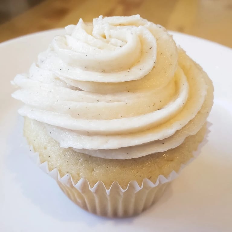 Freshly baked vanilla cupcakes, beautifully frosted with buttercream, ready for a special occasion.