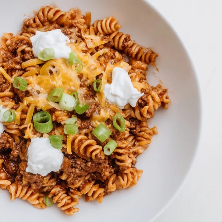 A comforting close-up showcases melted cheese atop savory one-pot taco pasta, ready to be enjoyed.