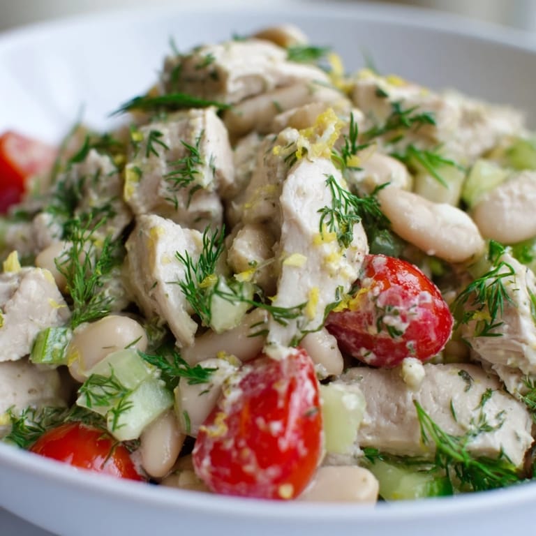 Overhead view of Lemony White Bean Chicken Salad, showcasing juicy chicken, creamy cannellini beans, and fresh parsley on a rustic wooden table.