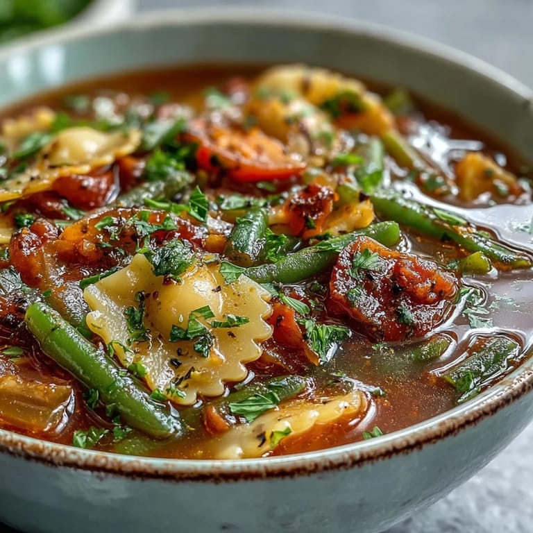 Freshly prepared Minestrone Soup in a rustic bowl, served with crusty bread on the side for dipping.