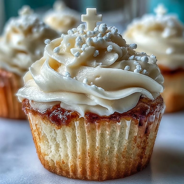 Soft vanilla cupcakes topped with creamy buttercream and elegant white fondant cross decorations.