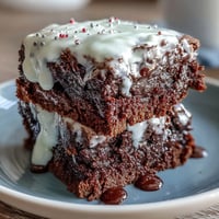 Festive Fourth of July brownie bites topped with creamy vanilla frosting and patriotic red, white, and blue sprinkles.